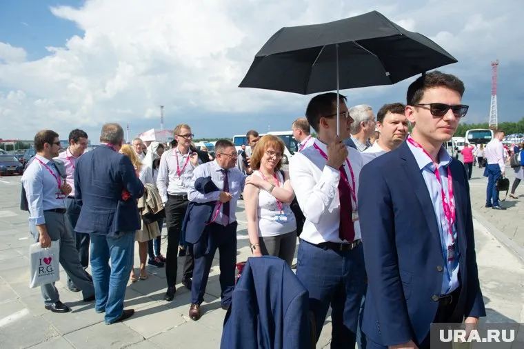 Люди стоят под солнцем, дожидаясь своей очереди