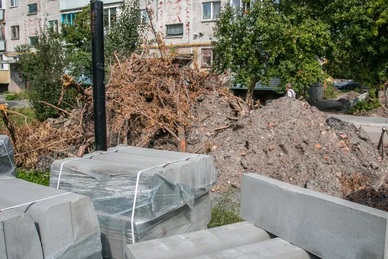 Неубранные городские помойки. Курган, куча земли, двор дома, бордюры