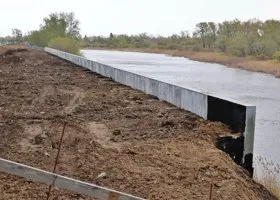 В Кургане дамбу возле незаконной высотки укрепили многометровой бетонной стеной