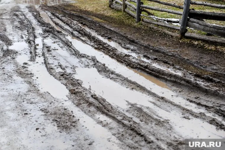 В межсезонье дорога к мосту превращается в непроезжий участок