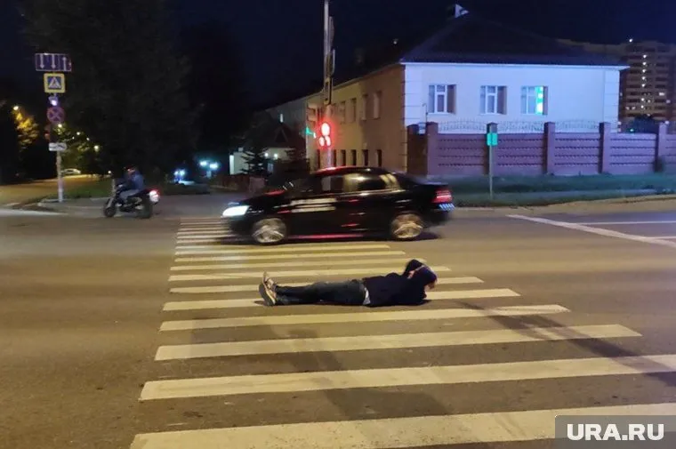 Мужчина улегся посреди дороги на пешеходном переходе