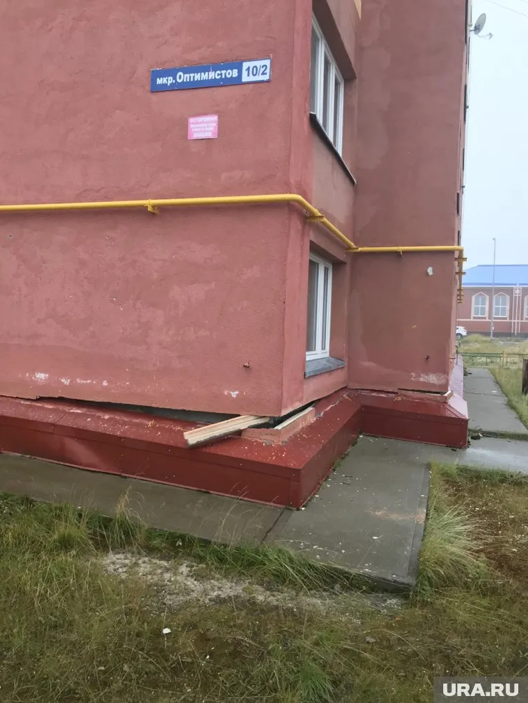 В расщелину между домом и фундаментом вставили деревянный брусок