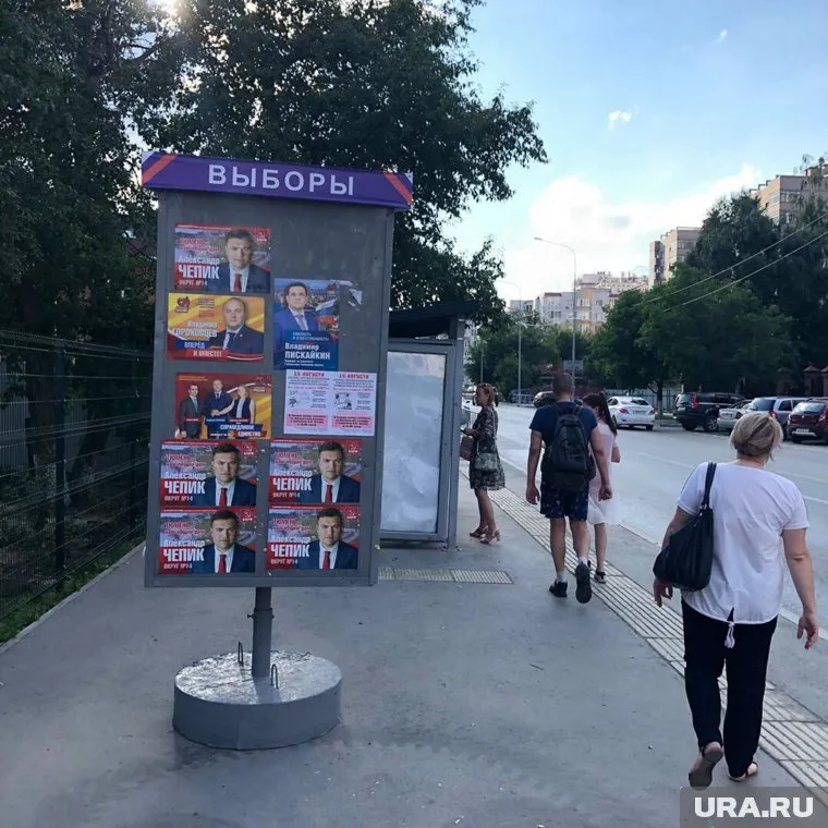 Политическая реклама на стендах издевательски сочетается с коммерческой и социальной