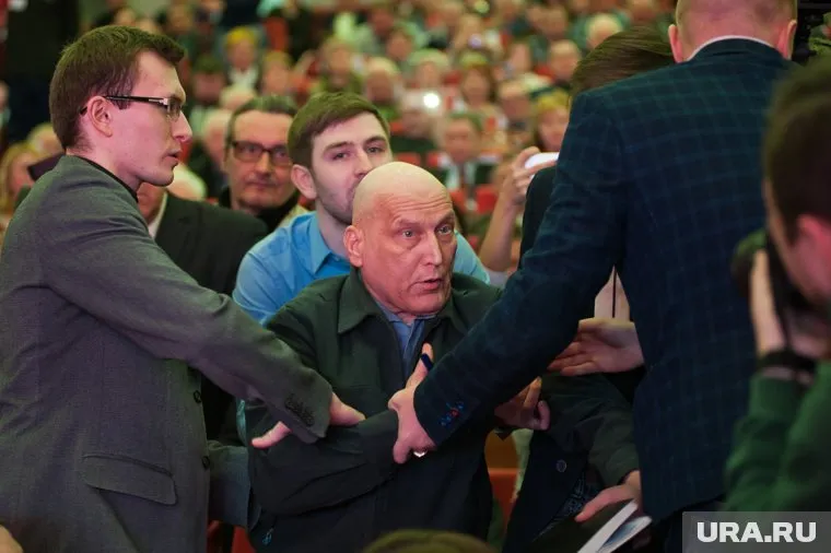 Пожилого мужчину силой вывели из зала