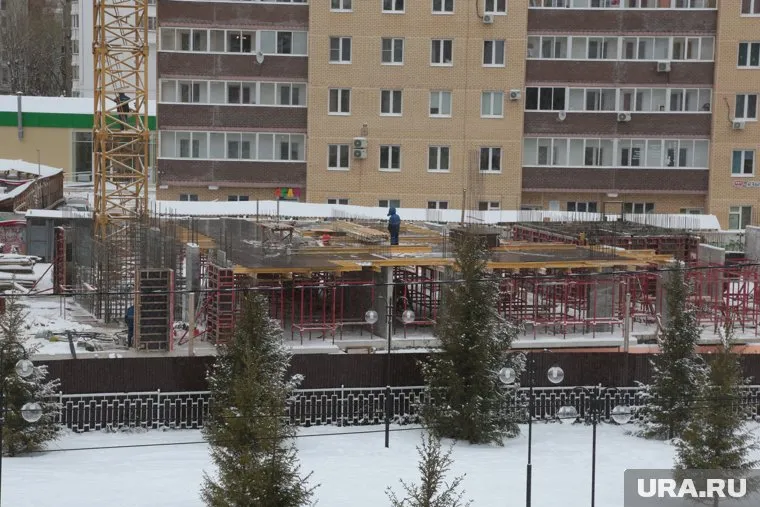 На стройплощадке, где возводится жилой дом, появились рабочие и строительная техника