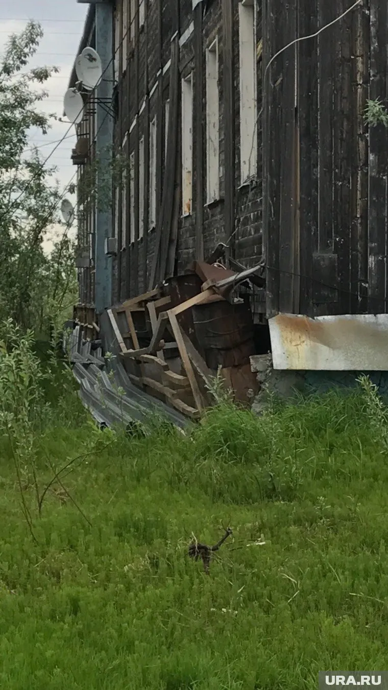 Обрушивающийся дом подпирают досками и бочками