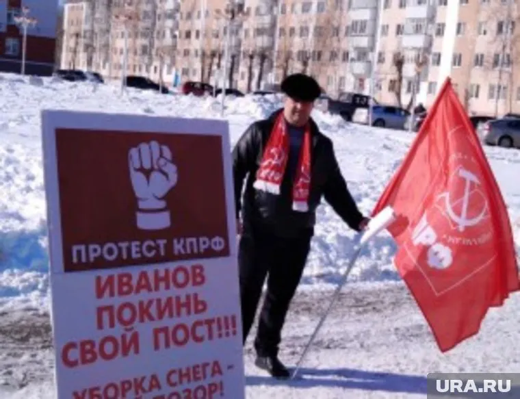 Коммунист Дмитрий Зеленский пикетирует на фоне заснеженной центральной площади Урая