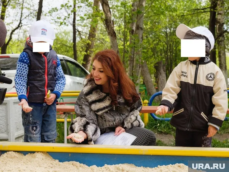 На детей, играющих в песочнице, надели кепки с символикой «Единой России»