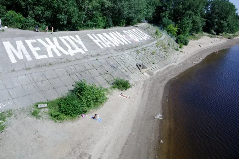 Под руководством Тимофея Ради подростки нарисовали арт-объект рядом с Коммунальным мостом. Пермь, берег, надпись, между нами вода