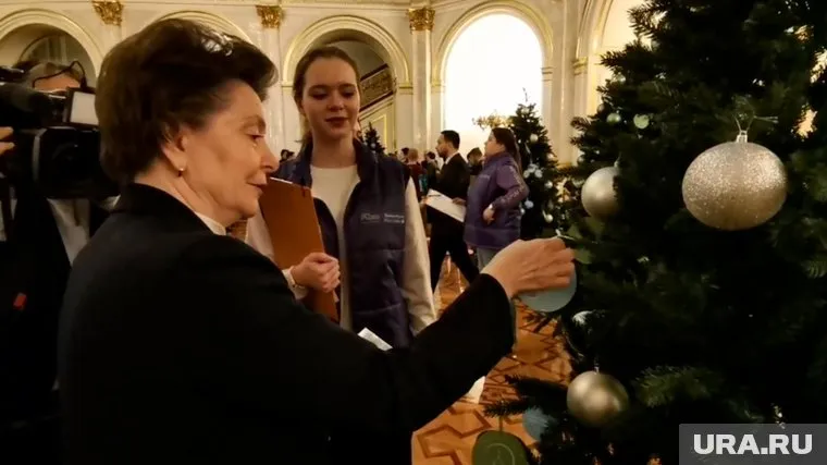 Комарова сняла с елки две карточки с пожеланиями детей