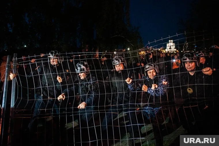 Забор, который на снимке пытаются удержать от протестующих силовики, стал главным символом гражданского конфликта в Екатеринбурге