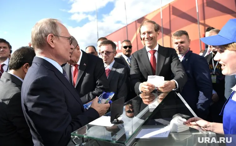 Владимир Путин (слева) отдает сдачу с мороженого министру Денису Мантурову