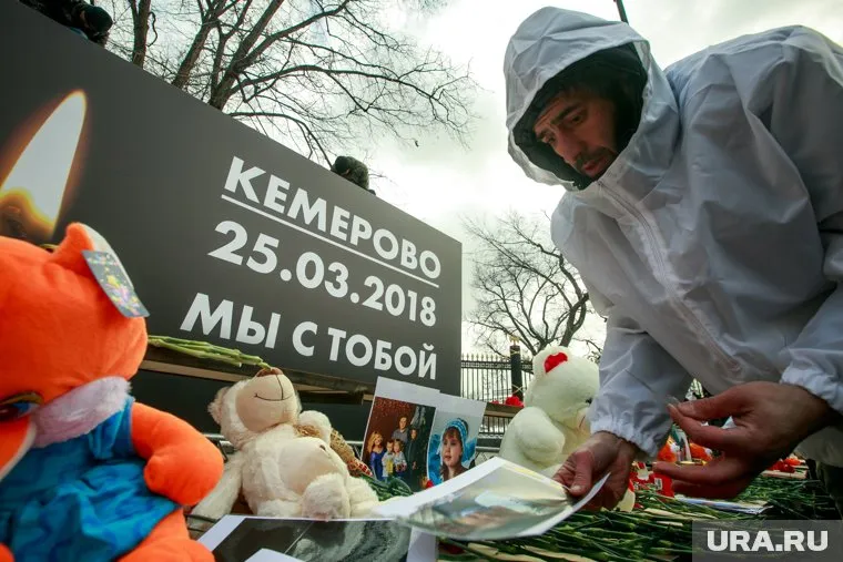 Люди массово несут цветы и мягкие игрушки