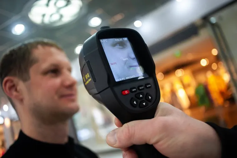 Сотрудники охраны проверяют тепловизорами температуру у посетителей торгового центра. Екатеринбург