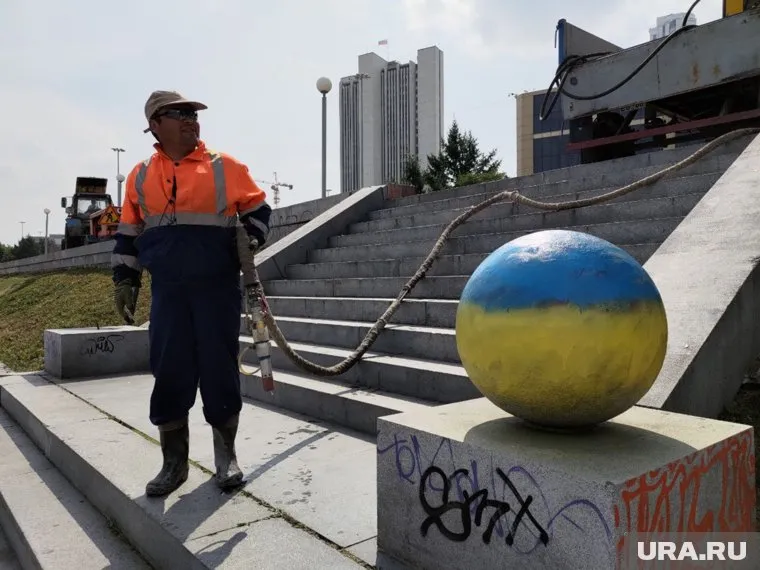 Несколько коммунальщиков приехали на Октябрьскую площадь в Екатеринбурге, чтобы отмыть ее от рисунков с флагами Украины