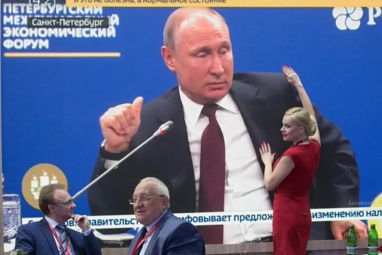 ПМЭФ-2018. Петербургский международный экономический форум 2018. Санкт-Петербург, обнимашки, девушка в красном, путин на экране, пмэф2018
