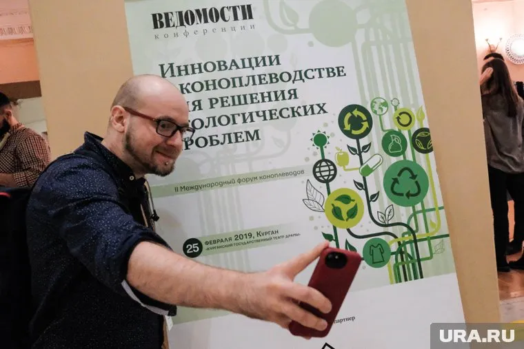 Участник форума делает селфи на фоне баннера