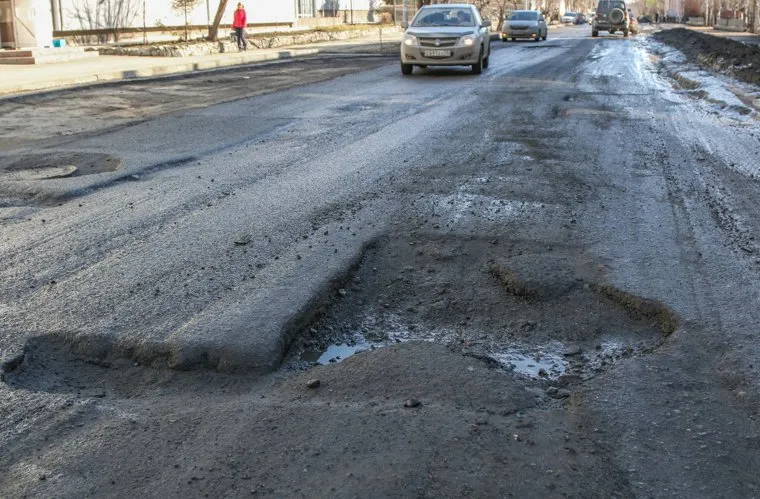 Разбитая дорога по улице Станционная в Кургане.