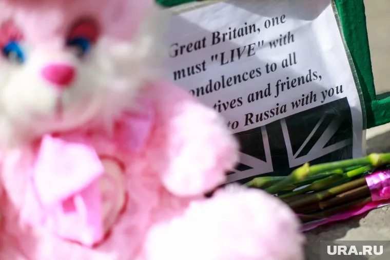 К посольству Великобритании в Москве после теракта в Манчестере люди несут цветы и игрушки