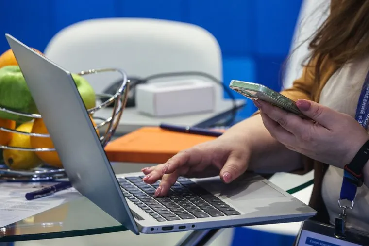 Ноутбуки и мобильники в руках. Москва