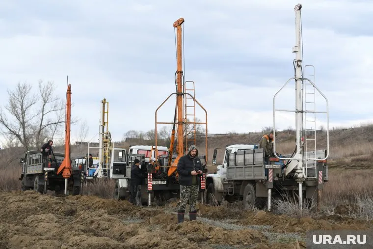 Рядом с Курганом делают дыры в земле, чтобы вода быстрее отступила