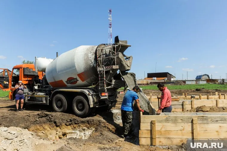 Рабочий полез очищать кузов бетономешалки