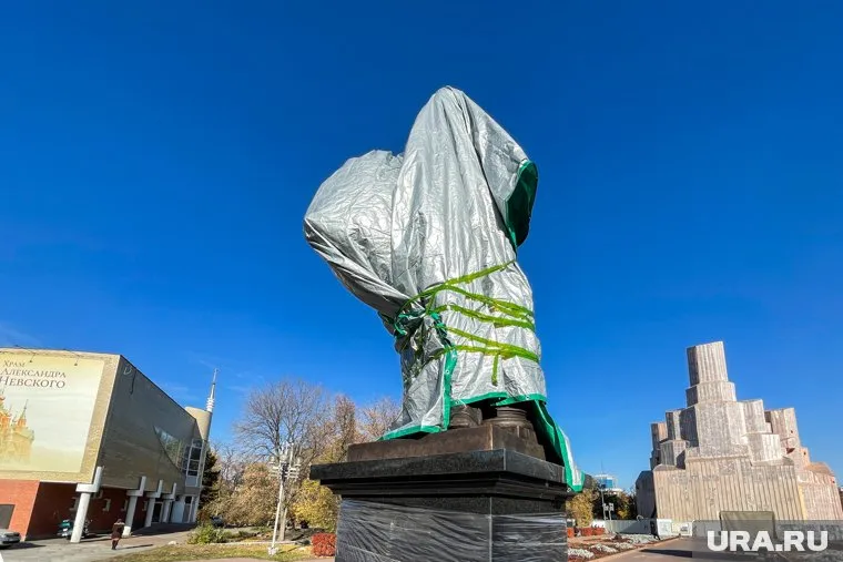 Противники необычной статуи собрались с другой стороны сада.