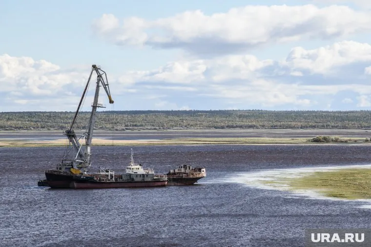 Баржа с грузовиками села на мель
