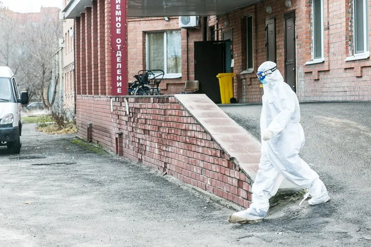 Скорая помощь и люди в защитных костюмах. Тюмень