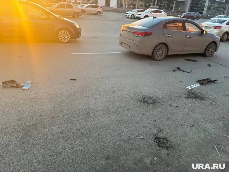 На асфальте на месте ДТП валяется автомобильный номер и куски от детской коляски