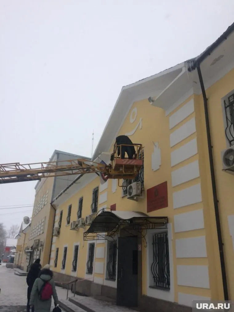 На снимке видно, что зона работ не огорожена и под висящей люлькой ходят дети