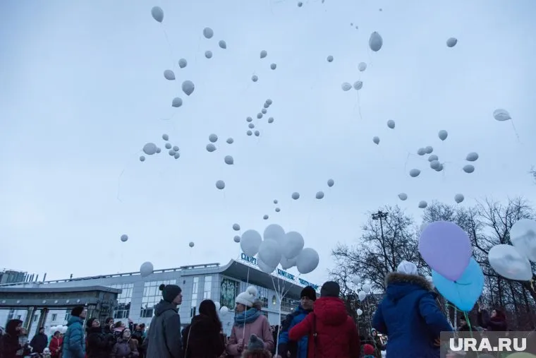 Люди выпускали в небо шарики, несли цветы и игрушки