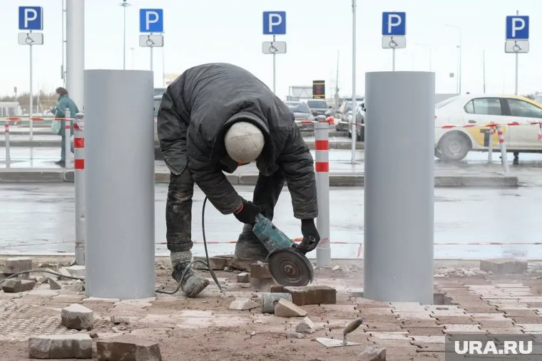 Рабочие меняют плитку, уложенную год назад