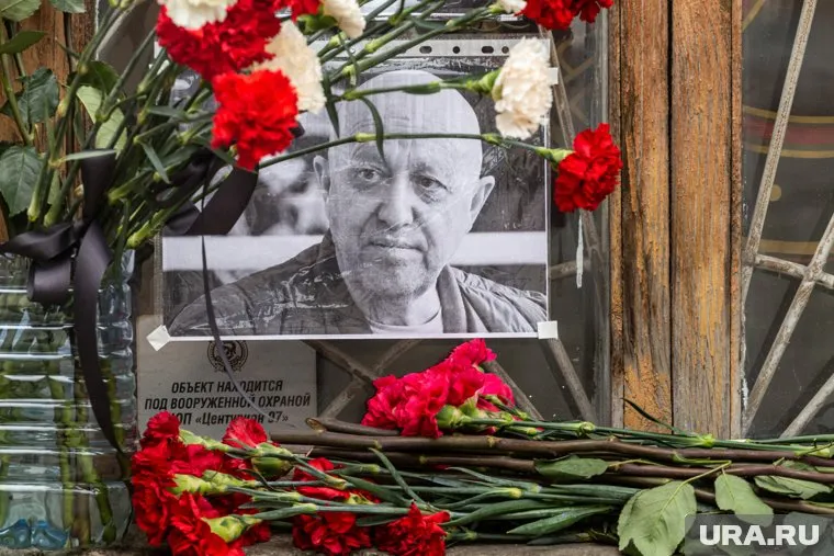 Люди оставляют цветы возле ограждения на Пороховском кладбище