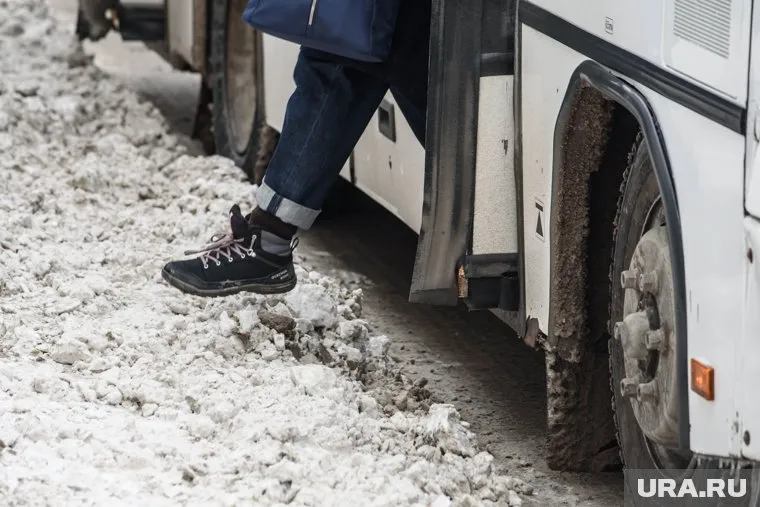 Автобус застрял в колее заснеженной дороги