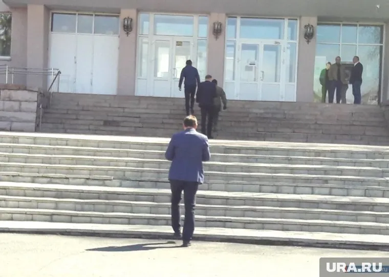 Два следователя пришли в мэрию Миасса в сопровождении силовика в маске (трое слева)