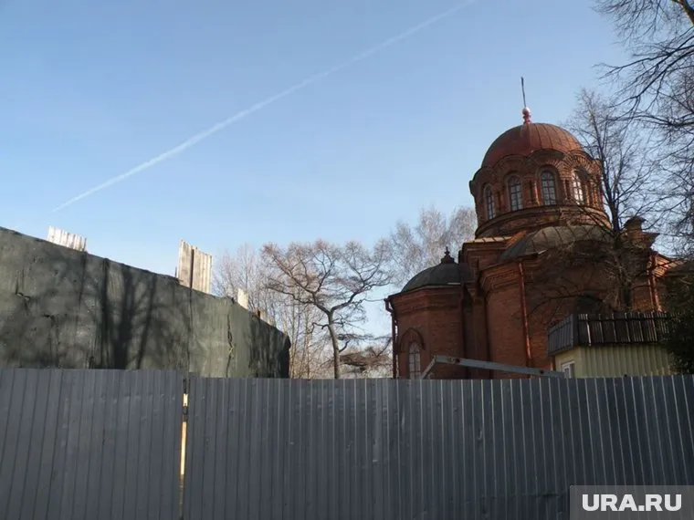 Территория церкви огорожена высоким забором