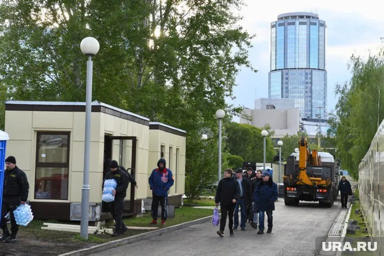 Работники убирают строительные вагончики