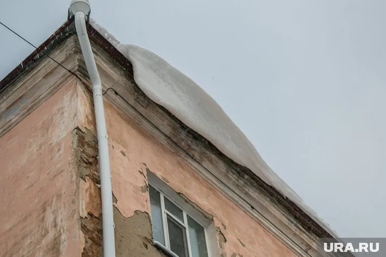 Снег сходит с крыш на пешеходов (архивное фото)