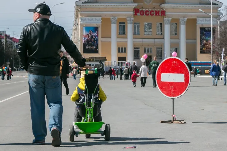 Первомайский митинг. Курган, кинотеатр россия, проезд запрещен, перекрытие дороги, знак кирпич, движение запрещено, мужчина с ребенком